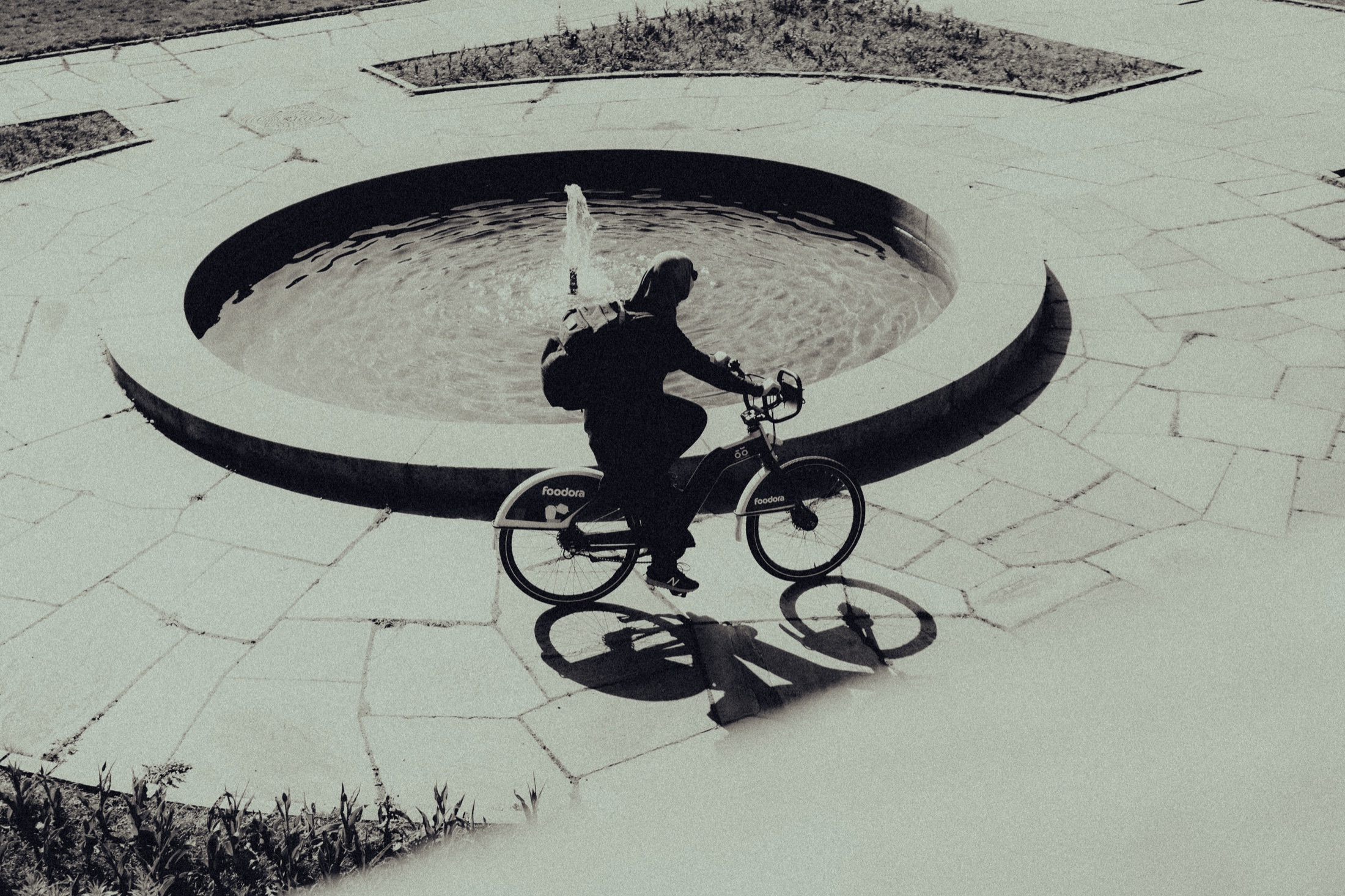 Cyclist and shadow beneath a circular structure
